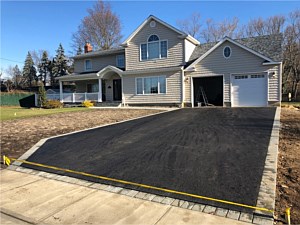 Asphalt driveway with gray charcoal brick borders